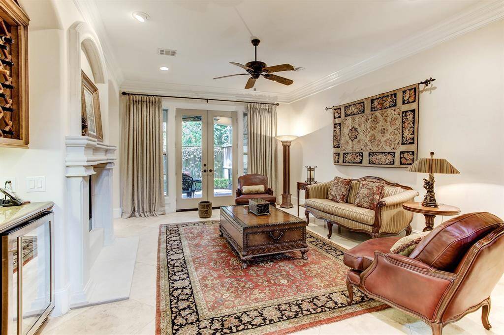 The light and bright living room features a dual fireplace that also serves the family room, kitchen and breakfast area.  There is wine storage, glass cabinets, and a wine chiller.  There are French doors leading to the outdoor kitchen, covered loggia and patio.