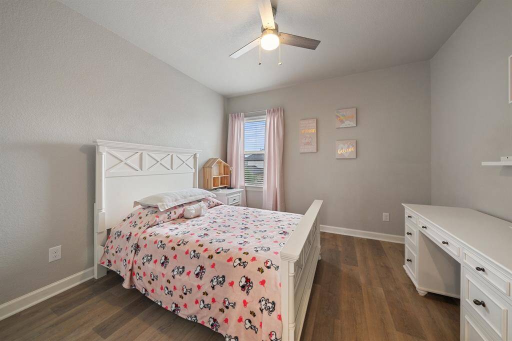 With beautiful luxury vinyl plank flooring, a ceiling fan, and a window with privacy blinds, this bedroom offers a serene and stylish space to unwind.