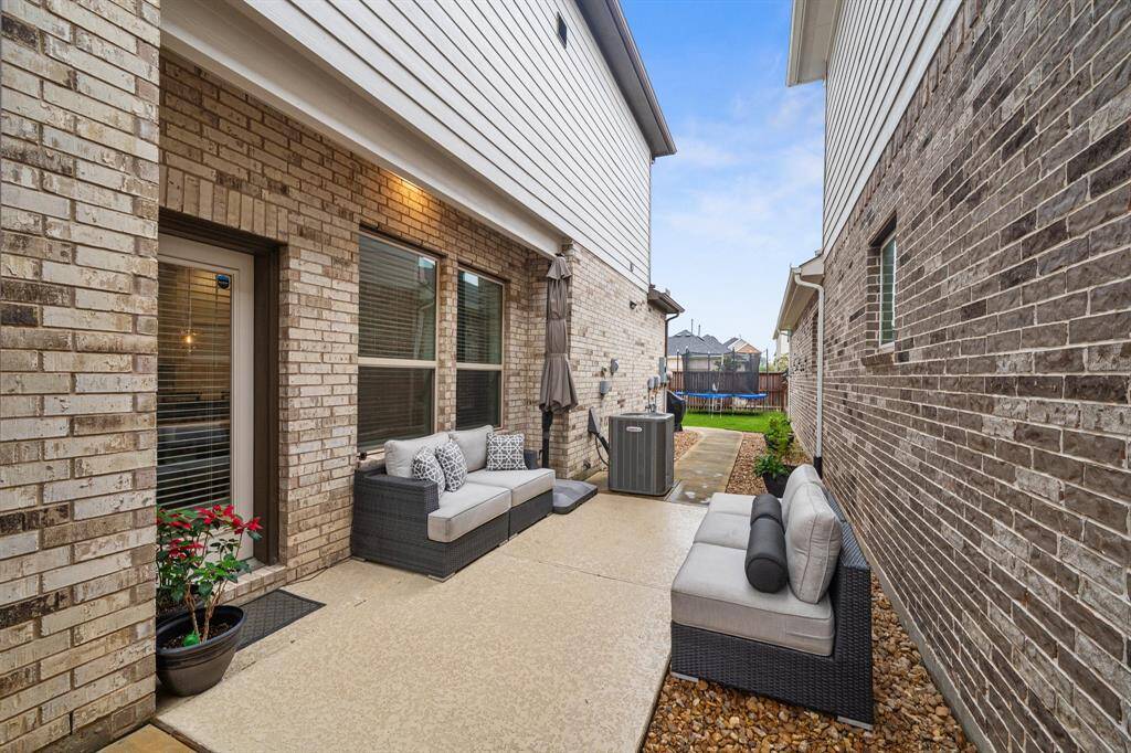 The backyard boasts a charming patio, complemented by tasteful landscaping and a convenient walkway leading to the rest of the outdoor space, perfect for enjoying the outdoors.