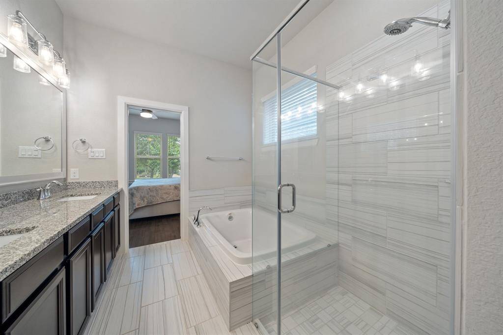 The primary bathroom also offers a luxurious soaking bathtub and an expansive tiled walk-in shower—perfect for unwinding in comfort and style.