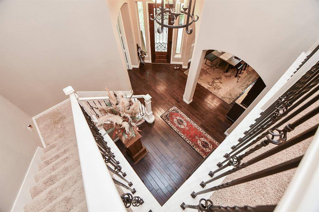The staircase has iron railing details and overlooks the entryway.