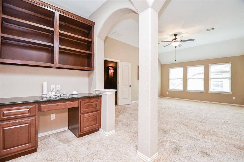 Right upstairs the game room features plush carpet, high ceilings, custom paint, and a desk perfect for working from home.