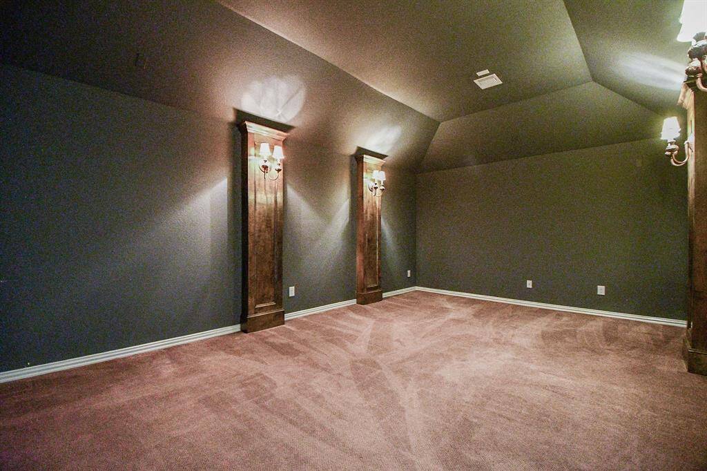 The media room features custom paint, plush carpet, and custom lighting.