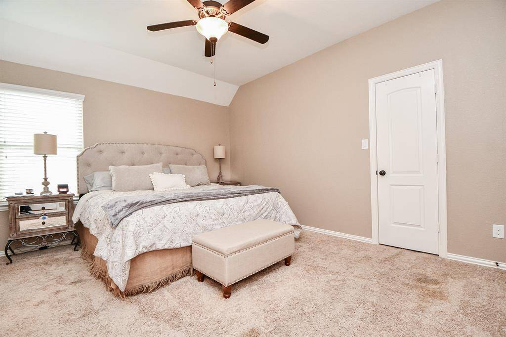 Secondary bedroom features awindow and plush carpet.