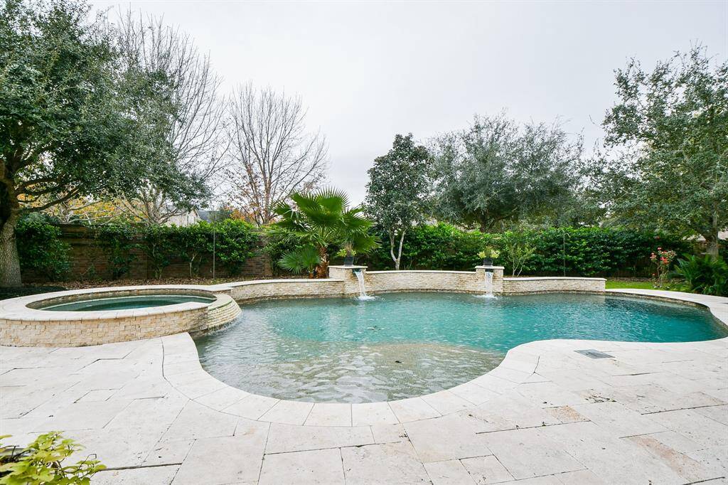 The pool features a spa and waterfalls.