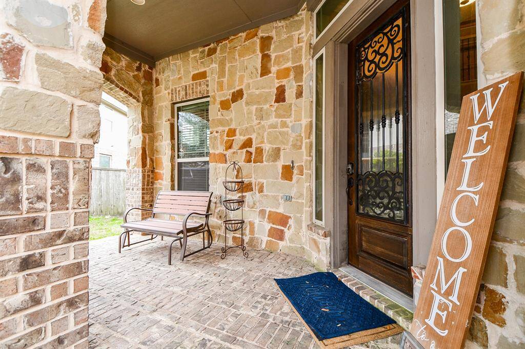 Approaching the front door you will see the brick and stone elevation and covered front porch.