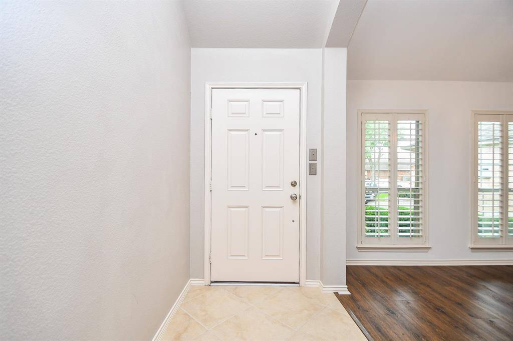 Handsome front door and covered entryway with brick-laid porch made safe for all your Amazon packages and for your friends and family to dive under on a rainy day.
