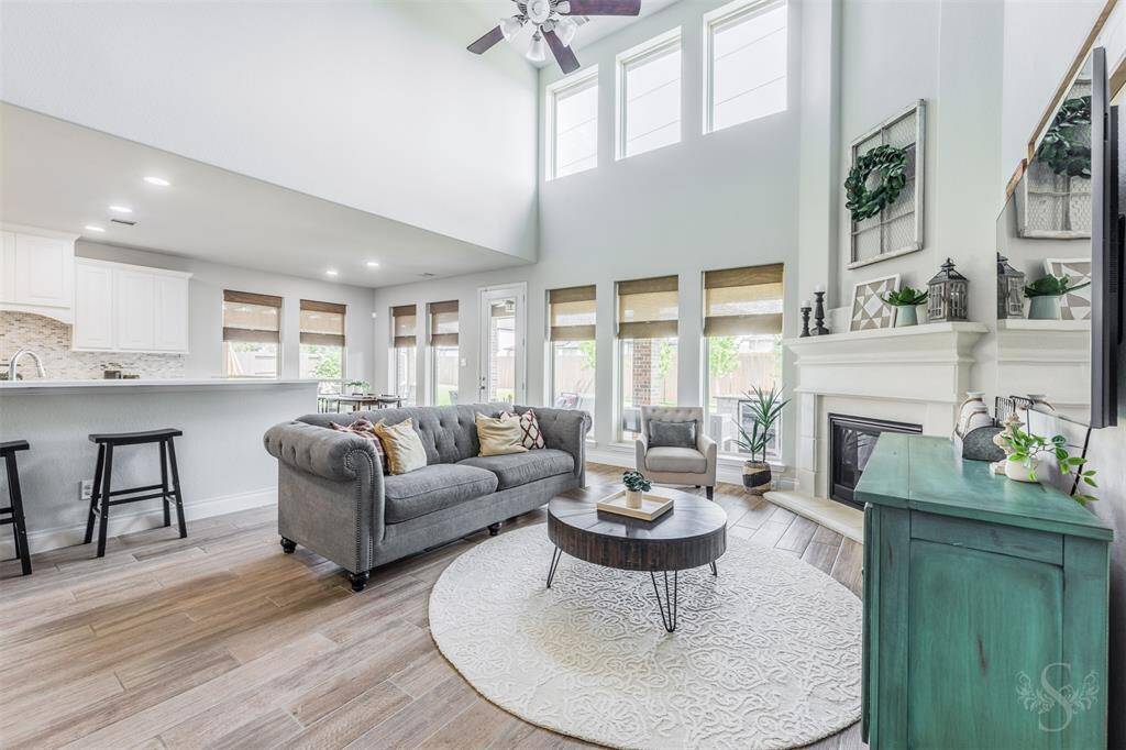 A wall of windows fills the family room with natural light while offering views of the backyard retreat. The fireplace and airy layout create a perfect setting for everyday living and entertaining.