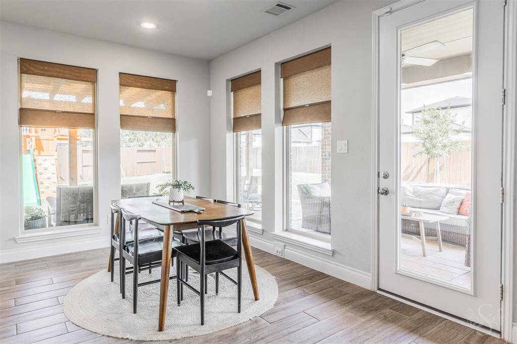 The breakfast room offers a cheerful setting with a wall of windows overlooking the backyard and patio. Natural light and backyard views create the perfect spot to start your day.