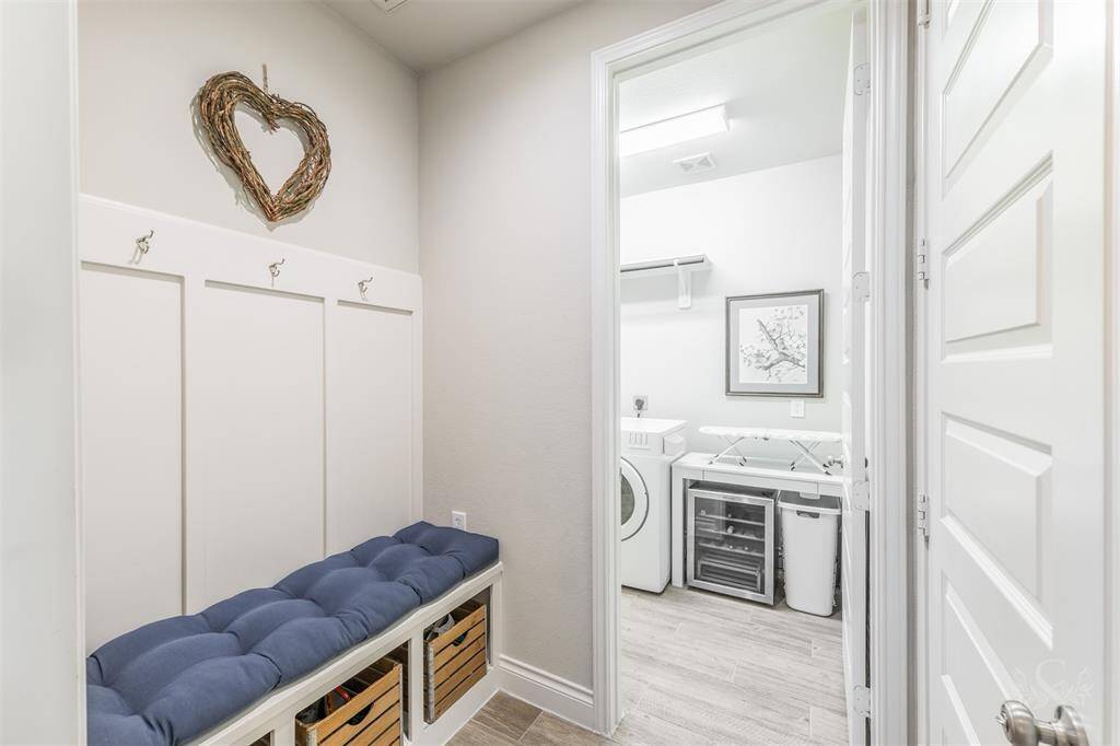 This charming mudroom features a built-in bench with cubbies and wall hooks, perfect for organizing daily essentials. Located just off the garage, it's a practical and stylish entry point into the home.