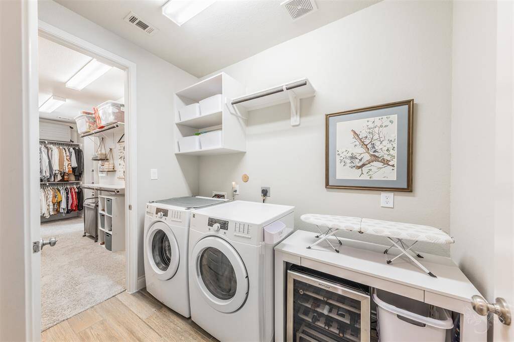 The spacious laundry room includes a wine fridge, folding counter, open shelving, and hanging space. This functional space is both stylish and efficient. Enjoy seamless convenience with direct access from the laundry room into the expansive primary closet.