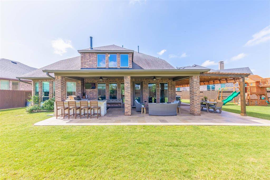This fully equipped outdoor kitchen includes stainless steel appliances, granite countertops, and a beverage fridge- ideal for effortless al fresco cooking. Overhead lighting and a ceiling fan ensure comfort from day to evening.