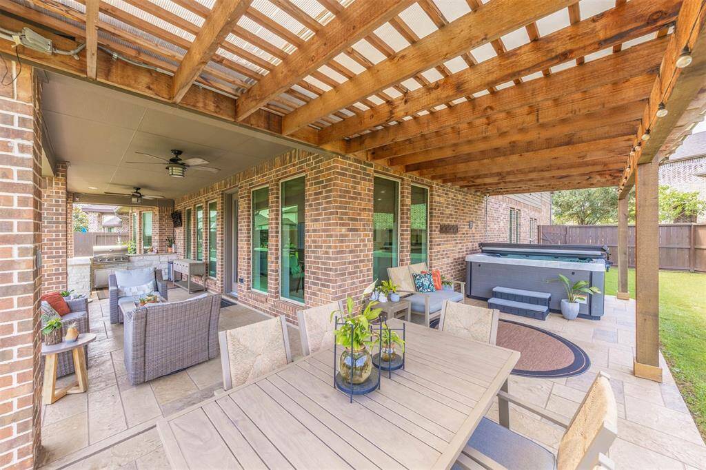 Expansive backyard with a covered patio, hot tub (included), and a separate fire pit area - ready for family fun and outdoor entertaining. *Pergola swing is NOT included (family item)