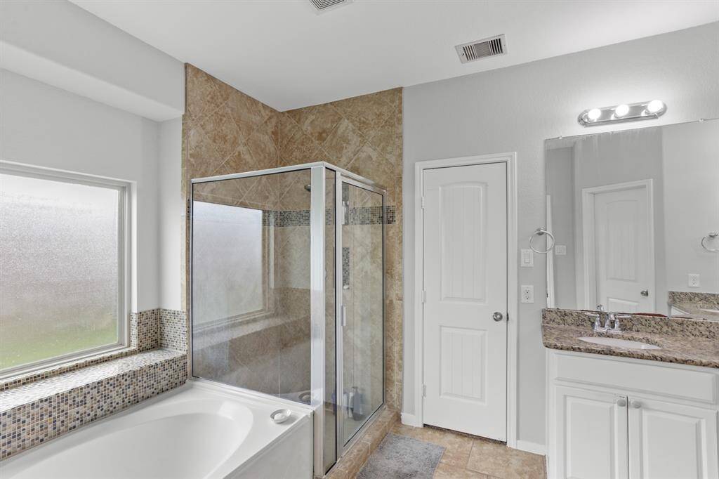 Welcome to your very own retreat! Relax after a long day in this wonderful Primary Bathroom with garden tub, and a glass enclosed shower.