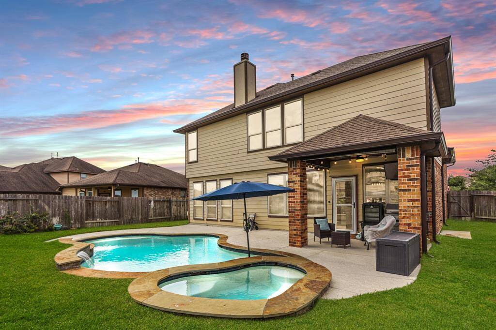 This backyard offers tons of green space, an INCREDIBLE sparkling pool, a covered patio, and gorgeous landscaping perfect for relaxing and entertaining family and friends!