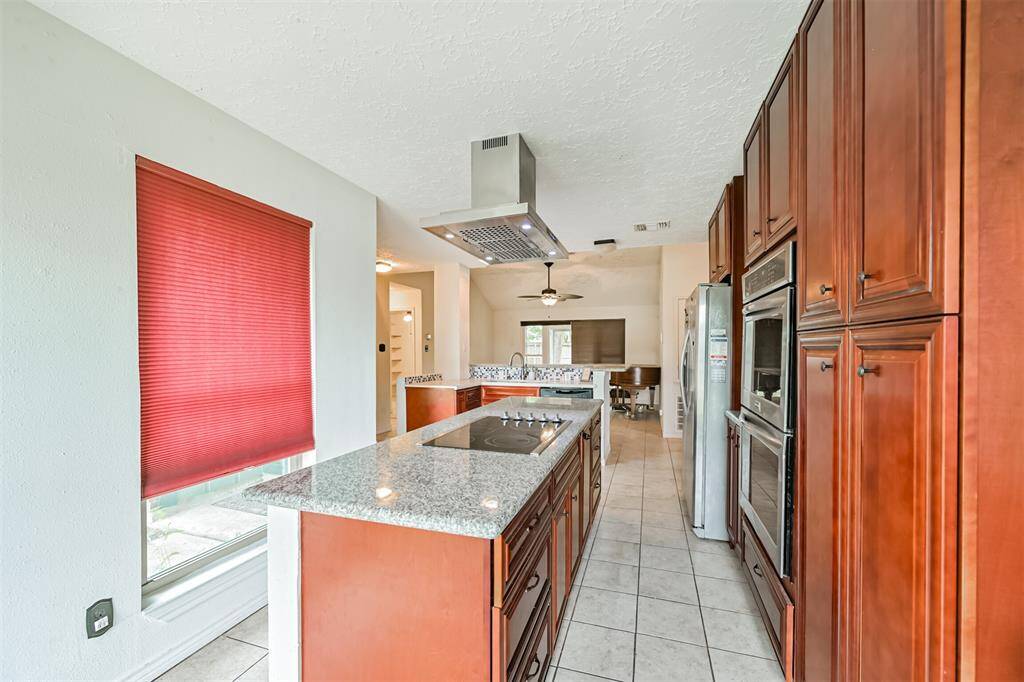 Chef's eat-in island kitchen features custom cabinets, lengthy countertops, stainless steel appliances and a breakfast bar