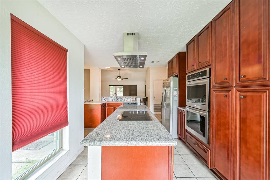 Chef's eat-in island kitchen features custom cabinets, lengthy countertops, stainless steel appliances and a breakfast bar