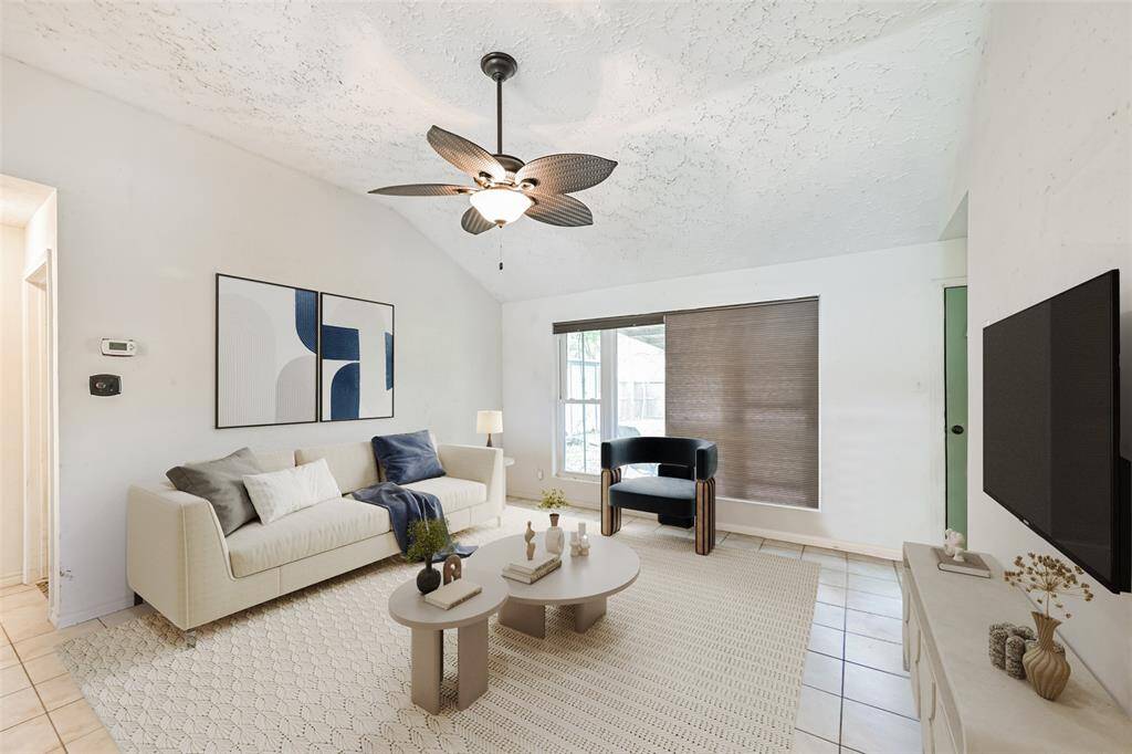 Living room open to the kitchen features high ceilings