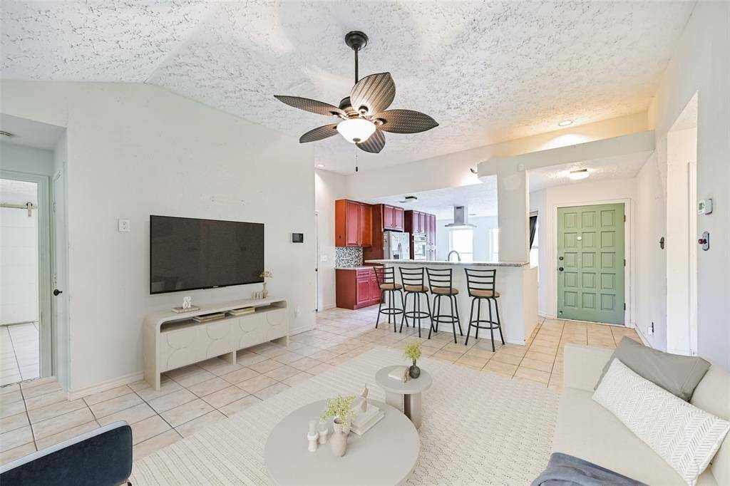 Living room open to the kitchen features high ceilings