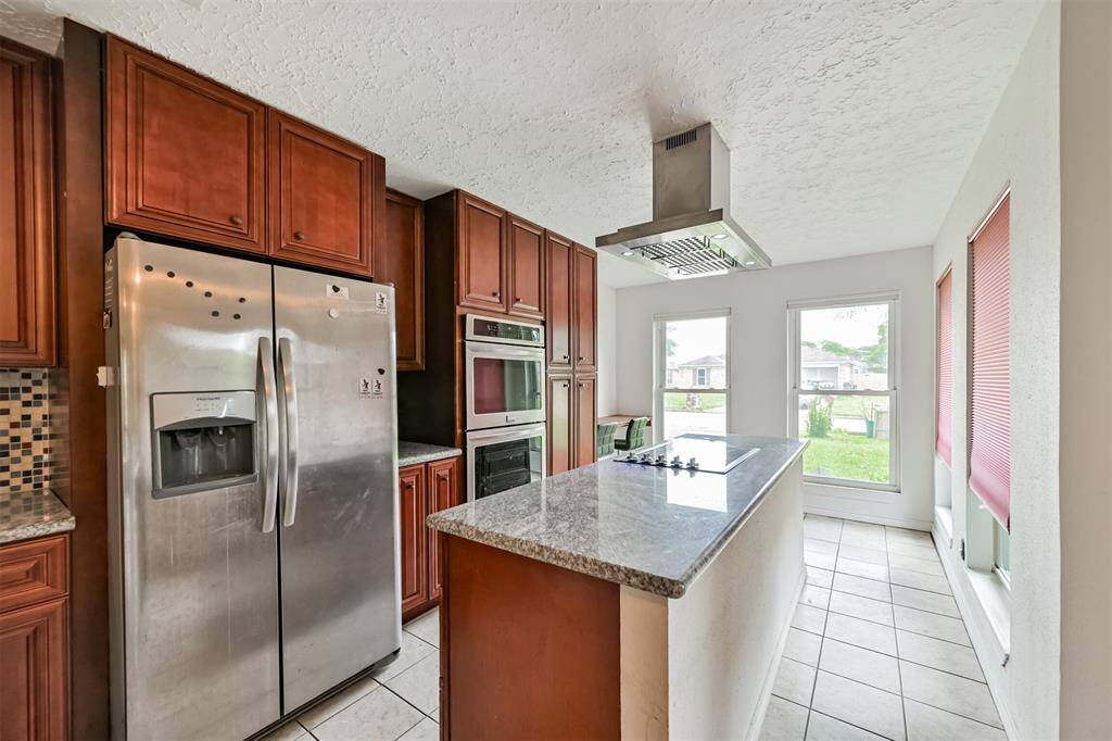 Chef's eat-in island kitchen features custom cabinets, lengthy countertops, stainless steel appliances and a breakfast bar