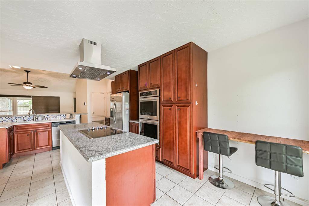 Chef's eat-in island kitchen features custom cabinets, lengthy countertops, stainless steel appliances and a breakfast bar