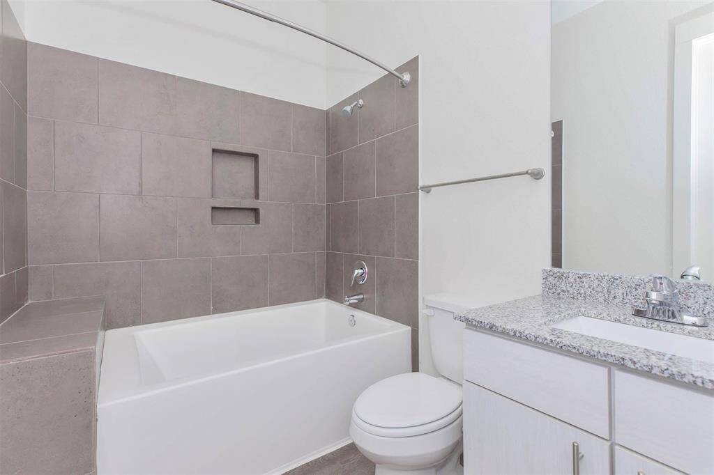 Secondary bathroom with granite countertops and tub/shower combo