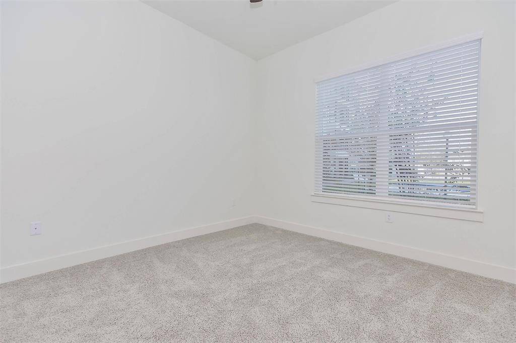 Spacious primary bedroom with large window for natural light