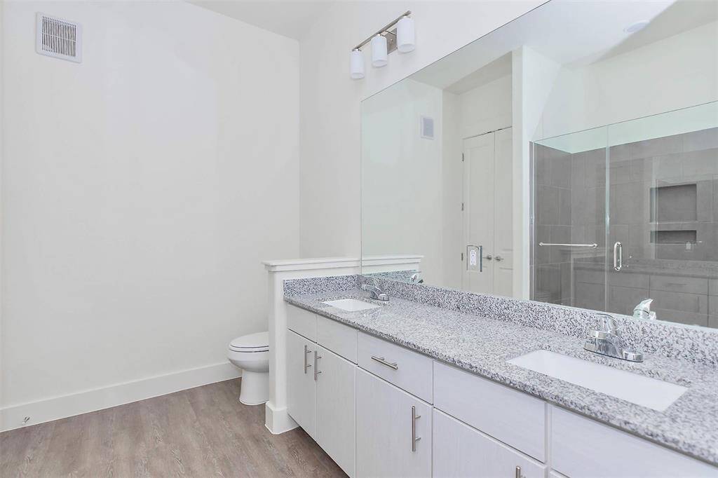 Primary bathroom with double sinks and granite countertops