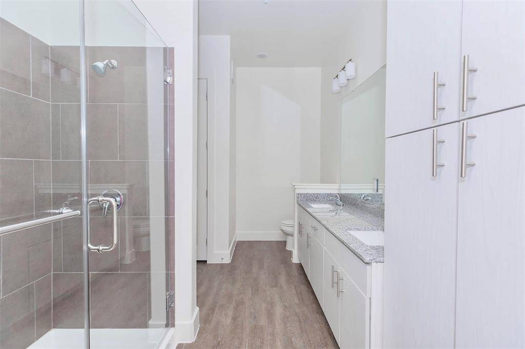 Large L-shaped bathroom with walk-in shower, walk-in closet, and linen closet