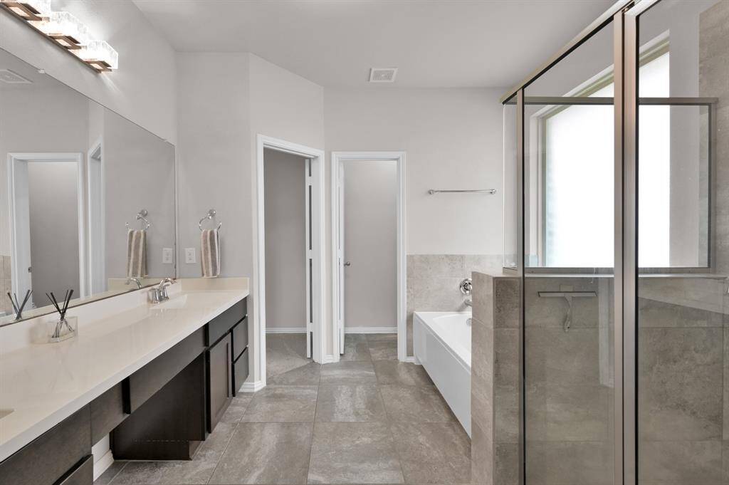 The primary bathroom has a built-in vanity with double sinks. The adjoining primary closet is absolutely incredible and large!