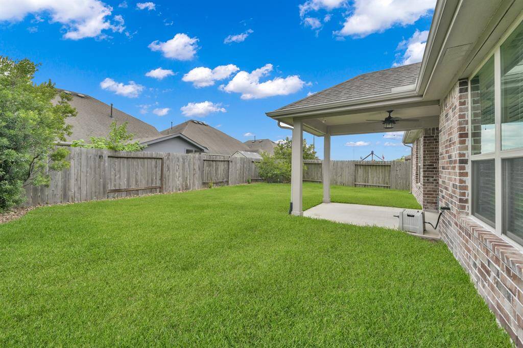 The backyard has plenty of space. The grass is lush and healthy.