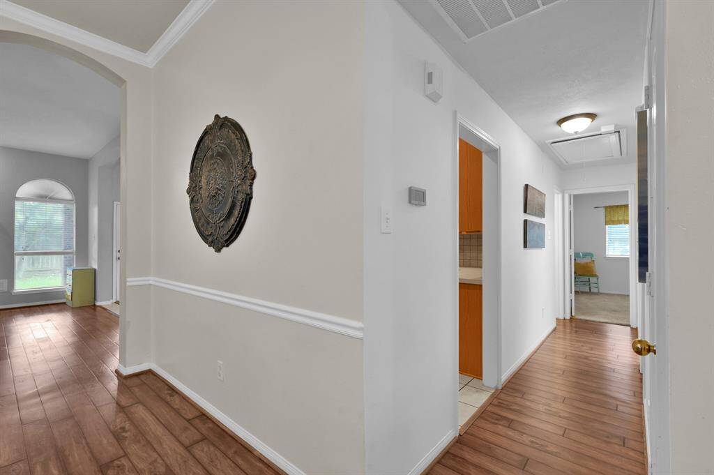 back into the living room space we can go left into the den or straight down the hallway for the laundry room, garage, 2 more secondary bedrooms and another full bathroom