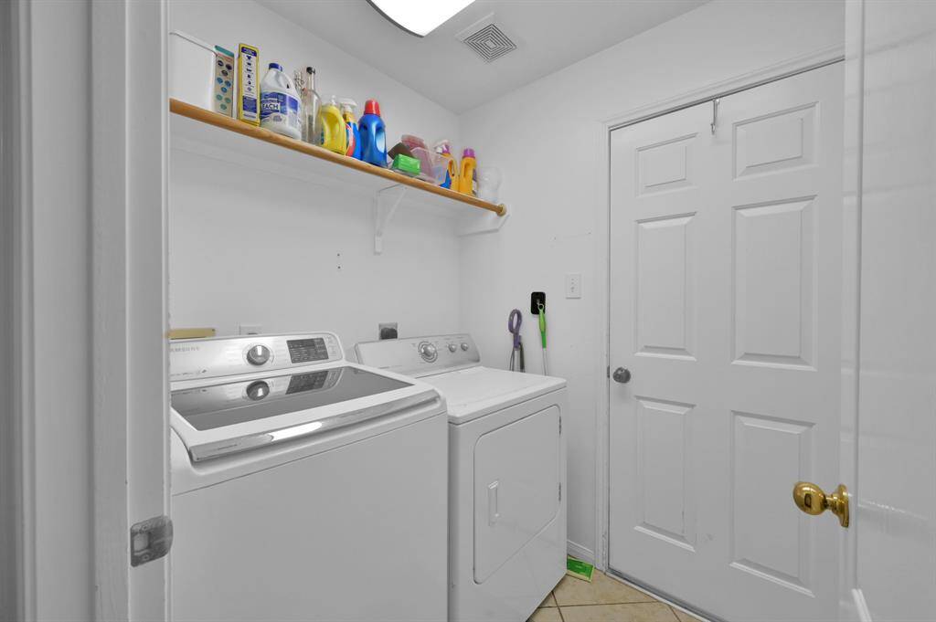 Laundry room towards the end of the hallway with door to the garage