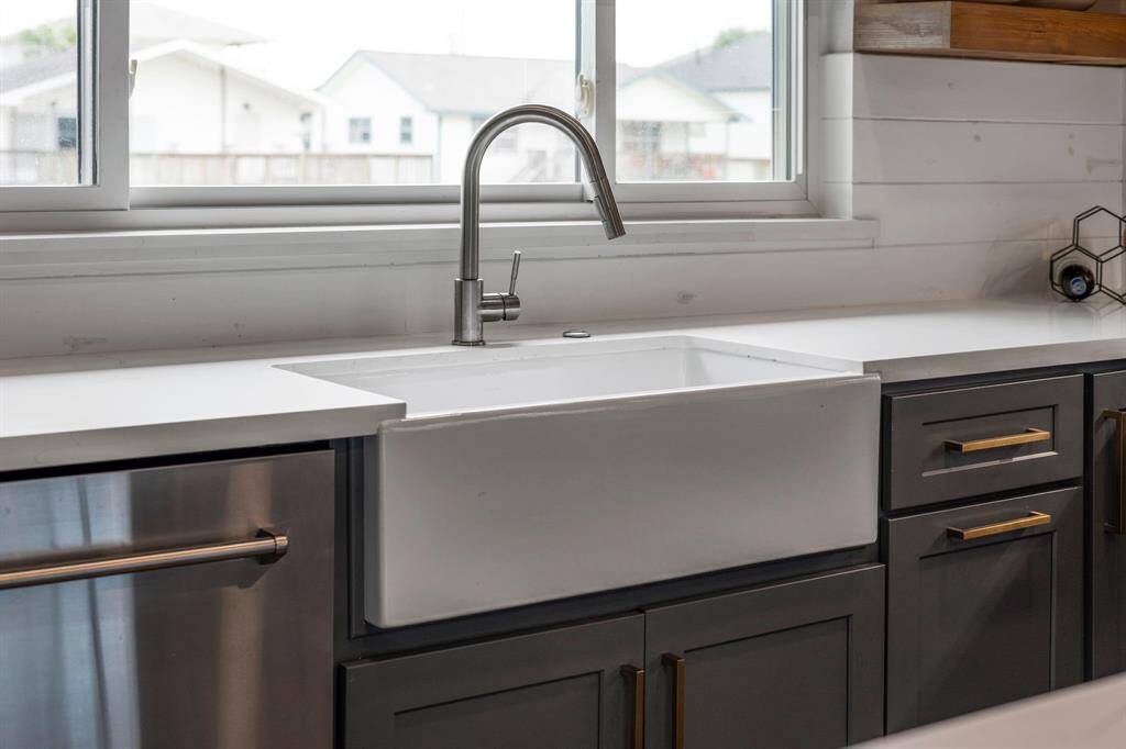 Deep basin undermount porcelain sink featuring a gooseneck faucet with pull-down sprayer.
