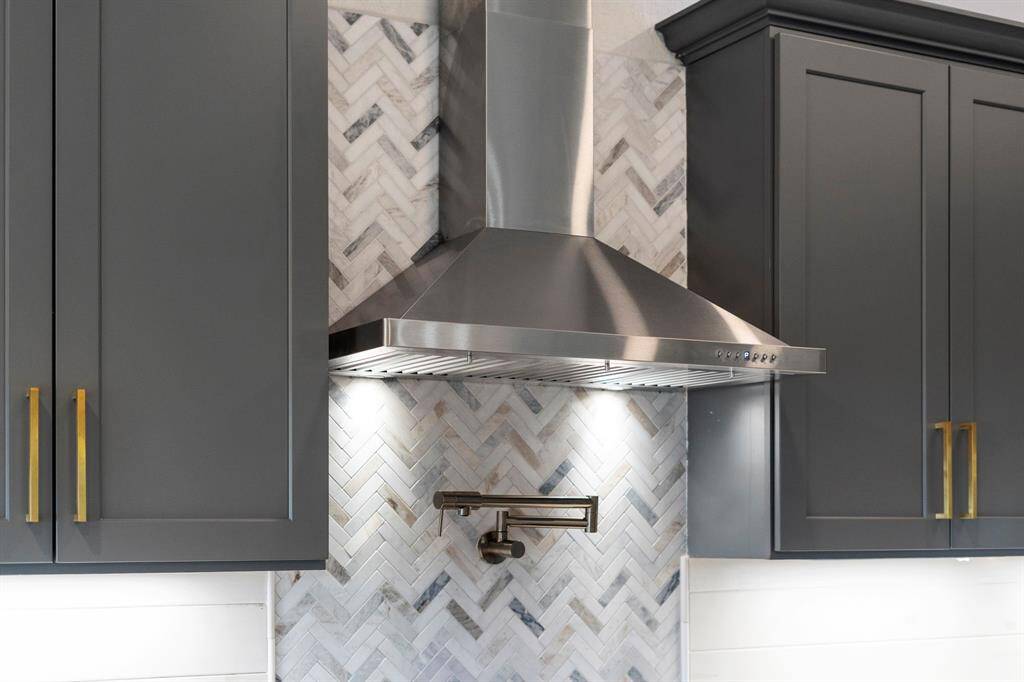 A stainless steel vent hood provides excellent ventilation, paired with a handy pot filler practical for filling large pots without having to carry them to the sink.