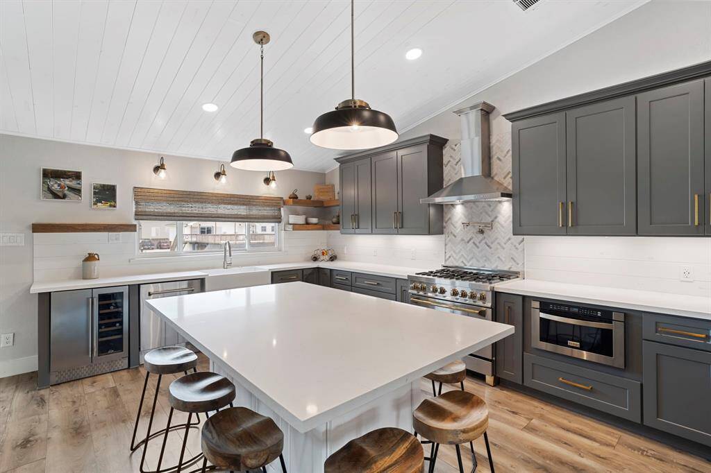 A built-in wine cooler and microwave add convenience and a sleek, integrated look to the kitchen’s modern design.