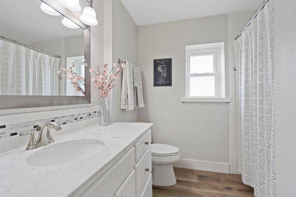 This beautifully renovated bathroom features a sleek vanity with a quartz countertop, complemented by a versatile shower/tub combo. New (2023) water heater.