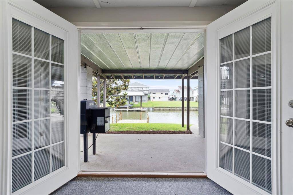 The Game Room French doors open to a patio overlooking serene waterfront views—perfect for indoor-outdoor entertaining.
