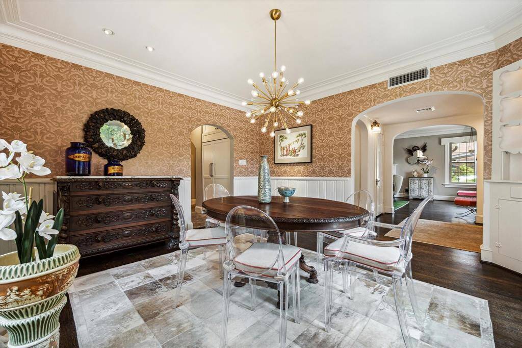 Wrapped in rich wallpaper and framed by graceful archways, the formal dining room offers a blend of classic detailing and modern flair.