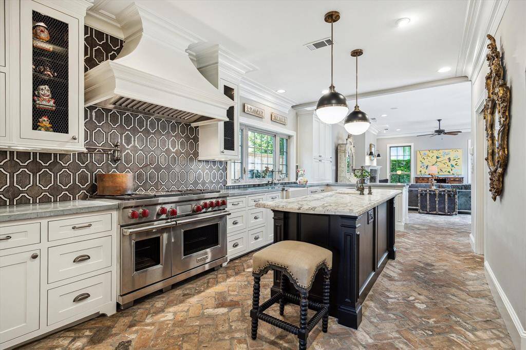 A thoughtfully designed 2012 addition introduces a spacious, open-concept chef’s kitchen featuring Wolf and Sub-Zero appliances, antique brick flooring, and stylish zinc and marble countertops.
