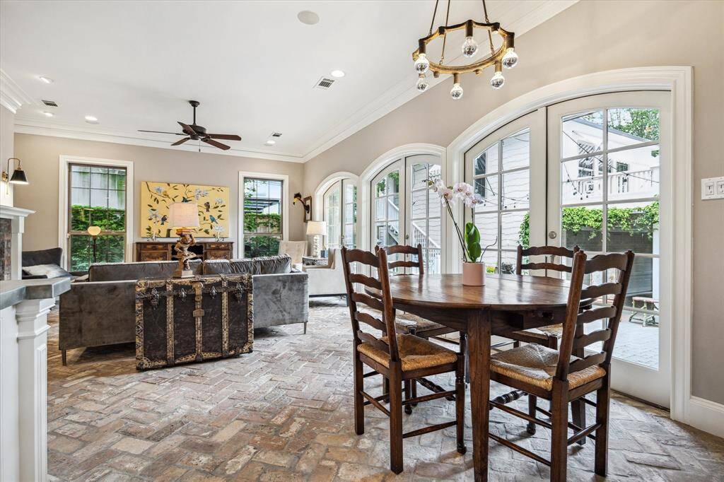 A harmonious flow connects chef's kitchen, breakfast area, light-filled family room with 10’ ceilings and serene views of the vine-draped courtyard.