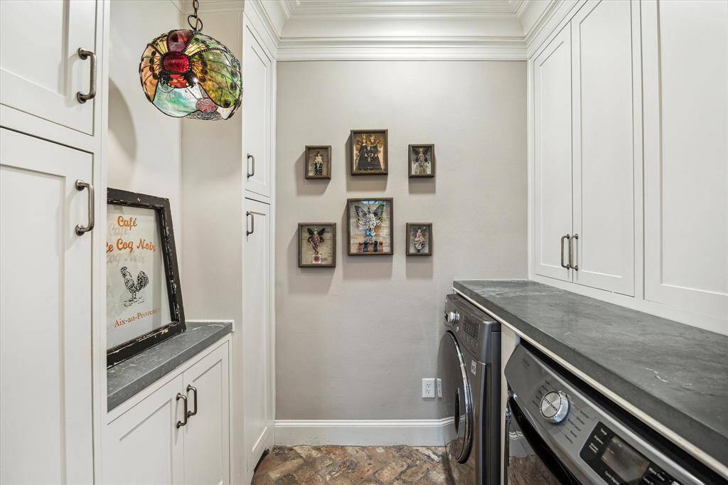 Efficient laundry room with zinc counters, ample storage, and cabinetry for pantry items.