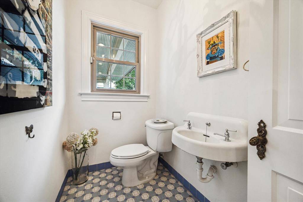 The powder bath exudes charm with vintage tile flooring and classic fixtures. A space that blends function with personality, perfect for guests.