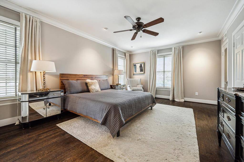 The serene primary bedroom features a soft, neutral palette and handsome hardwoods, creating a calming escape.