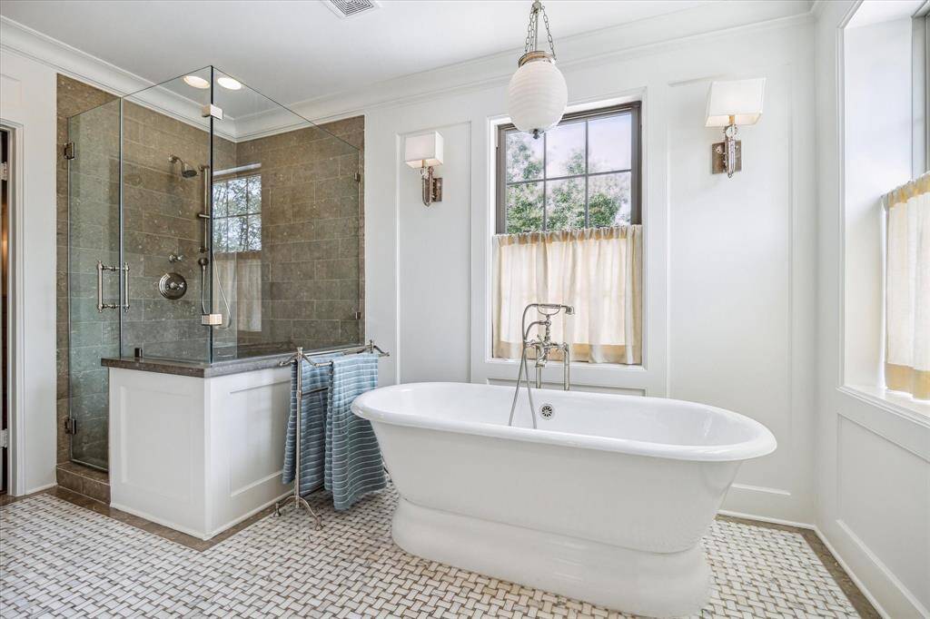 A glass-enclosed shower and freestanding tub share the spotlight in this spa-like ensuite.
