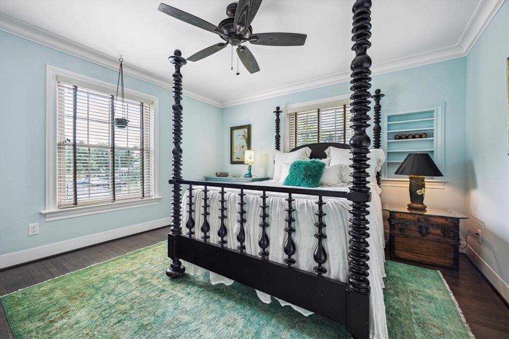 Cozy secondary bedroom with soft blue walls, crown molding, and window coverings.