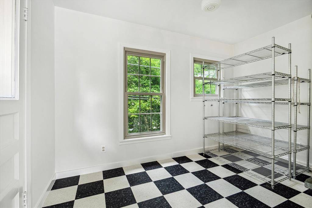 The first room upon entry once served as a kitchen and now provides a flexible area that could be reimagined as a prep kitchen, hobby room, or additional storage.