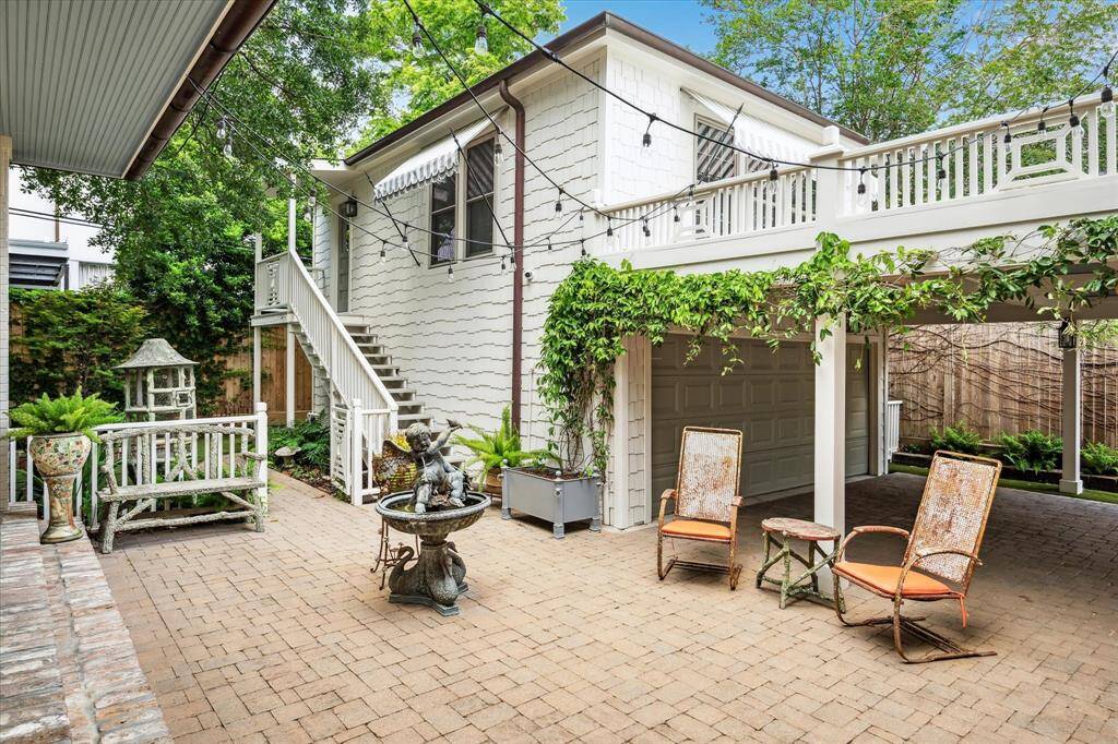 Beneath the carport, enjoy a spacious brick courtyard framed by greenery, offering covered parking and a tranquil seating area ideal for morning coffee or evening conversations.