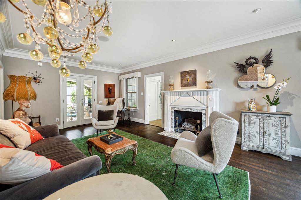 With soaring ceilings, crown molding, and a custom fireplace, this sophisticated living space blends architectural elegance with bold, artistic flair.