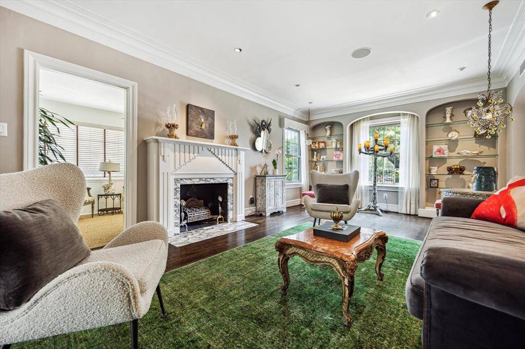 Framed by elegant crown molding and rich hardwoods, the living room is equal parts gallery and gathering space.